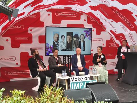 neljä panelistia istumassa lavalla ja keskustelemassa